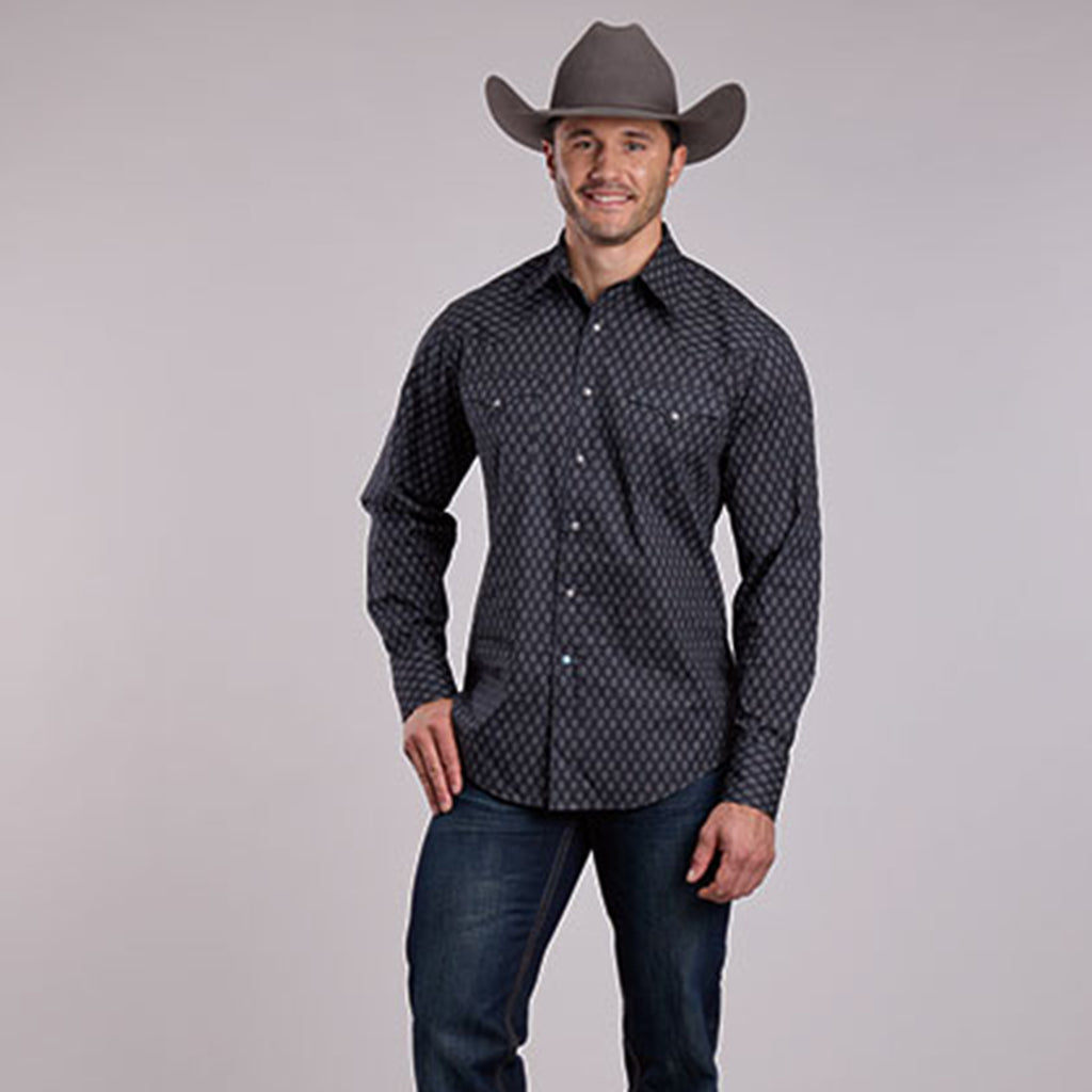 Full front side view of male model wearing the dark grey diamond print long sleeve shirt. 