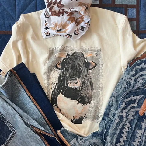 Sandstone Black & White Bull Tee in a flat lay with a bandanna, showing the bold black‑and‑white bull graphic on the sandstone fabric