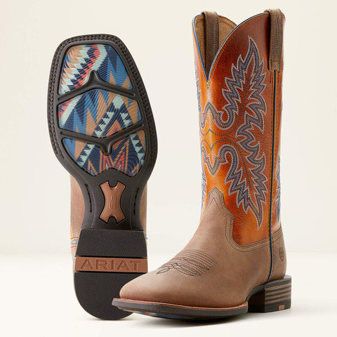 Left boot showing bottom of the boot with a rubber sole and Aztec designs. Right boot angled inwards showing orange shaft and blue and white stitching. Light brown leather boot.