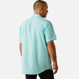 Back view of man wearing a light blue shirt with ariat logo.
