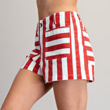 Side view of a model wearing red and white striped shorts, highlighting the breezy silhouette, soft fabric, and comfortable mid‑rise fit.