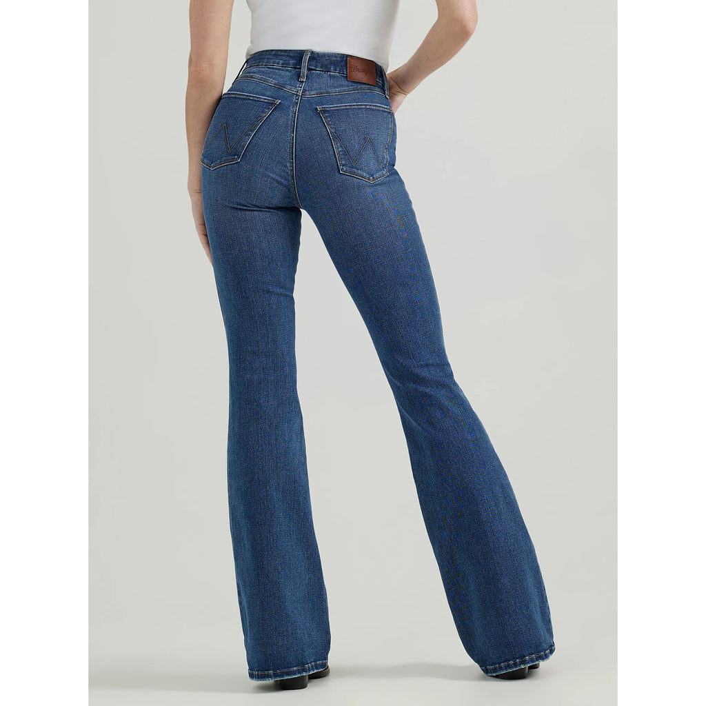 Person wearing high-waisted, flared blue jeans with stitched back pockets and a branded leather patch, 