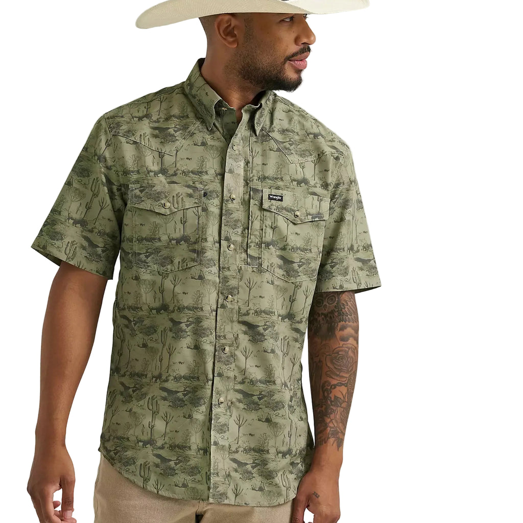 Front side view of green short sleeve pearl snap shirt that features a dark green desert print, double chest flap pockets, and shoulder yokes. 