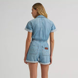 Back view of model wearing a Wrangler women’s denim snap utility romper featuring utility pockets, and relaxed short fit.