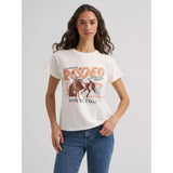 Model wearing the Wrangler women’s Bronc Rodeo Giddy Up tee, front view showing the bold bronc rider graphic, Western lettering, and relaxed everyday fit.