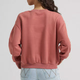 Back view of a model wearing the women’s Wrangler logo pullover crewneck, showing the plain back with no graphic, soft fleece fabric, and relaxed Western fit.
