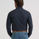 Back view of a model wearing the Wrangler Men’s Cody Johnson black spotted performance button down shirt, showing the Western back yoke, spotted pattern, and smooth performance fabric.