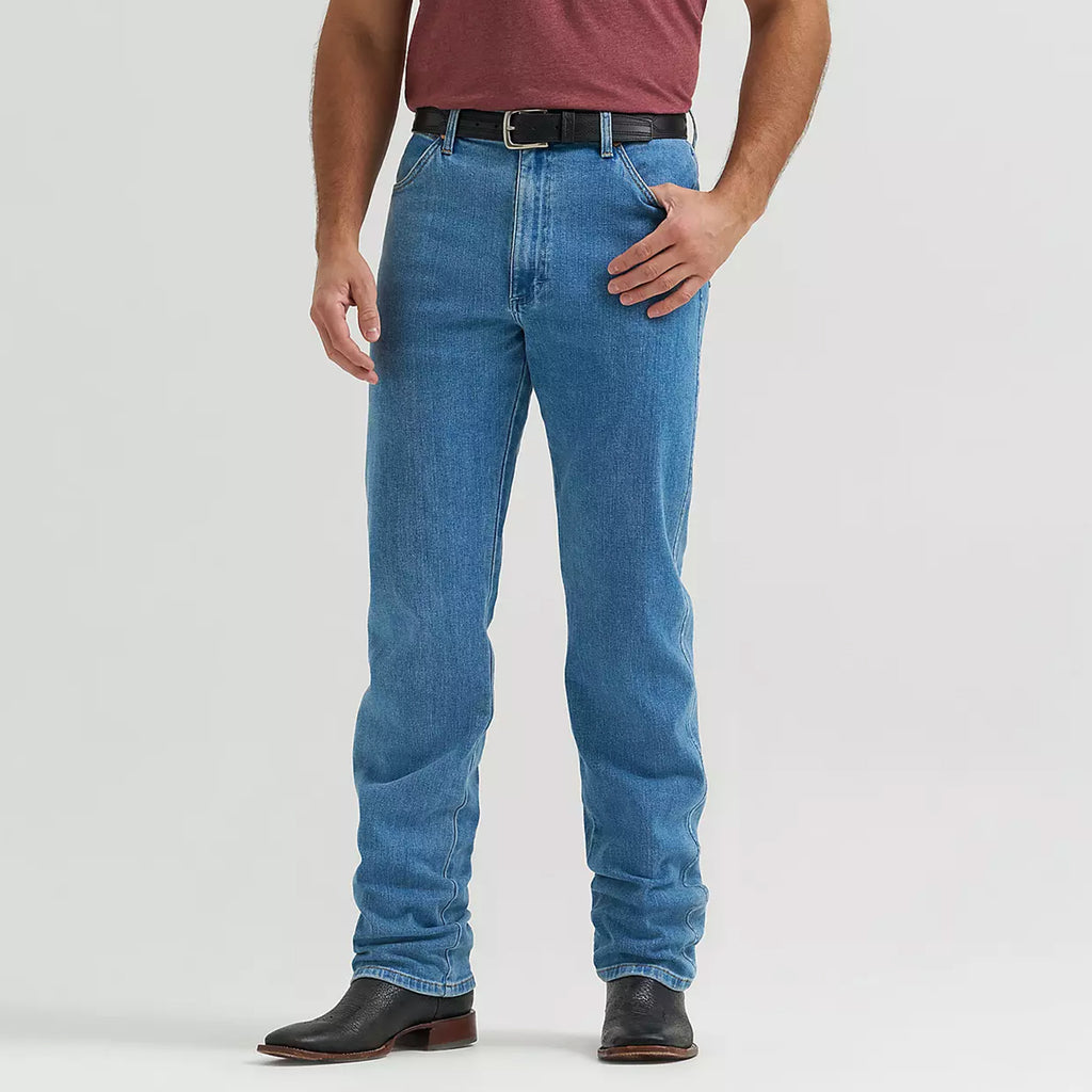 Model wearing Wrangler Tough Lite faded stone jeans, front view showing the lightweight denim, relaxed Western fit, and faded stone wash.