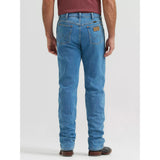 Back view of a model wearing Wrangler Tough Lite faded stone jeans, showing the Western yoke, back pockets, and classic Wrangler silhouette.