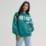 Model wearing a turquoise Wrangler logo hoodie, front view showing the bold chest logo, soft fleece fabric, and relaxed Western fit.