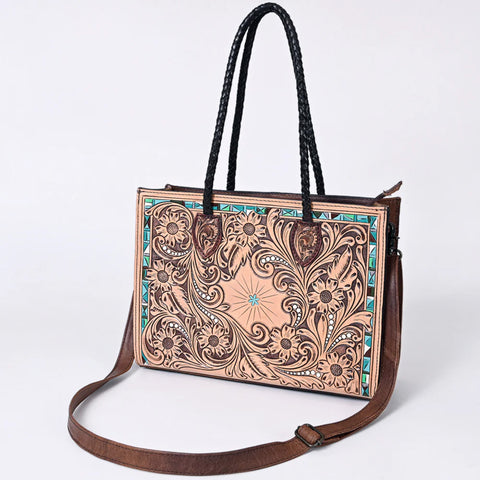 Leather tooled tote bag with turquoise painted accents on the front, two long straps on the top and one long shoulder strap. 
