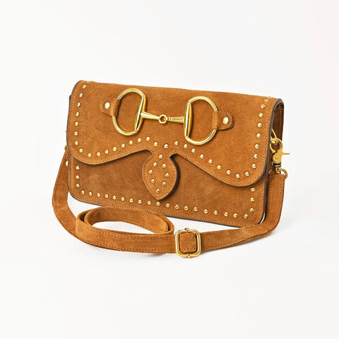 Brown suede purse with a large gold horse bit on the top flap and small gold studs that trace the outside. 