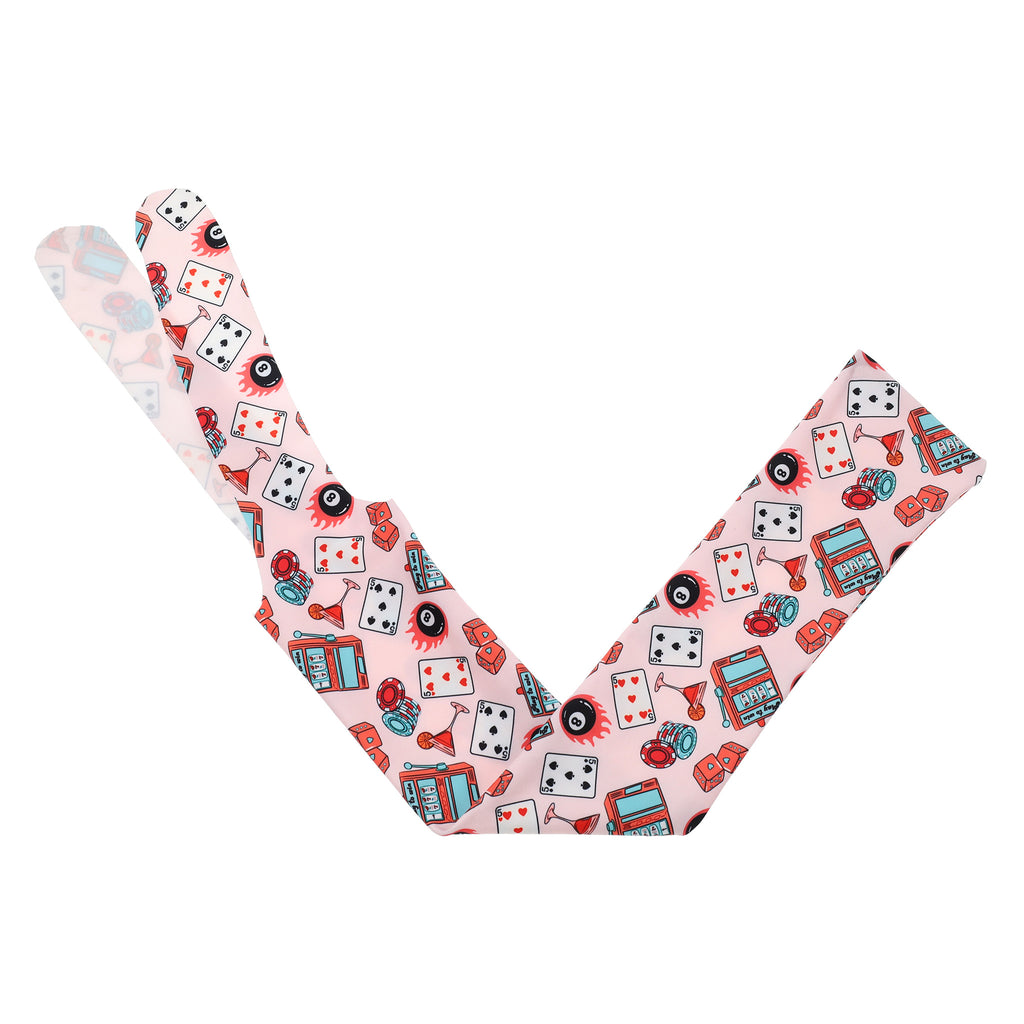 vibrant red and teal designs like playing cards, a martini glass, an 8 ball, and a slot machine on a tail bag