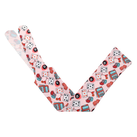 vibrant red and teal designs like playing cards, a martini glass, an 8 ball, and a slot machine on a tail bag