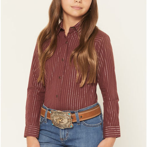 Girl Model facing the front is wearing a burgundy long sleeve pearl snap shirt. This Shirt has burgundy snaps and gold shimmer vertical stripes. 