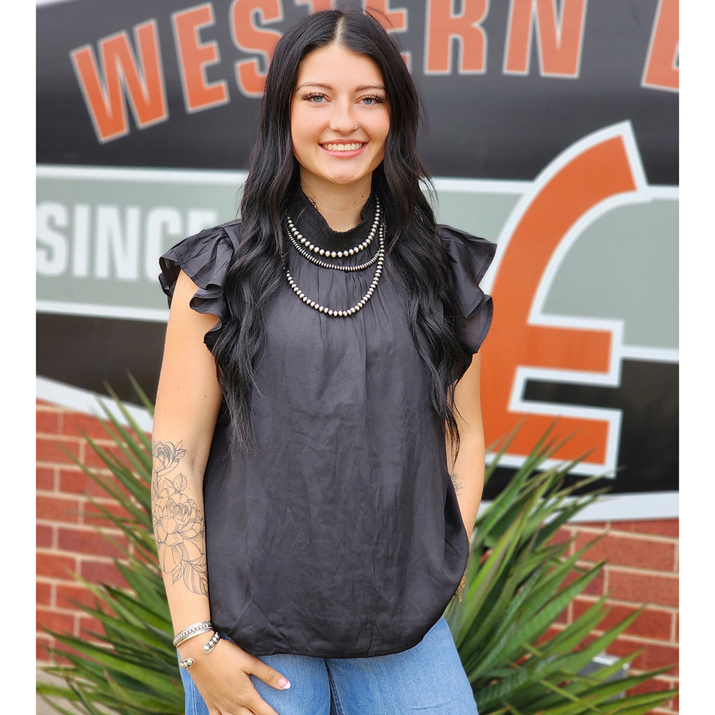 Black top features a smocked mock neck and short ruffle sleeves