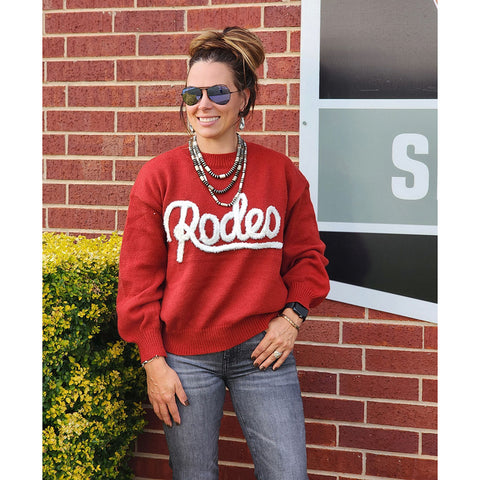 Woman wearing a red 'Rodeo' sweater