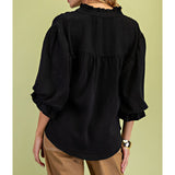 Back view of a model in the black 3/4 balloon sleeve blouse, showing the clean back line, gathered sleeve detail, and polished, versatile fit.