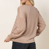Back view of a female model wearing the camel long sleeve shirt.