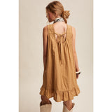 Back view of the model wearing the Textured Pleated Mini Dress, showing the tied‑back detail 
