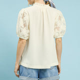 Woman wearing the Cream Flower Lace Sleeve Blouse, back view showing the lace sleeves and textured cream back panel.