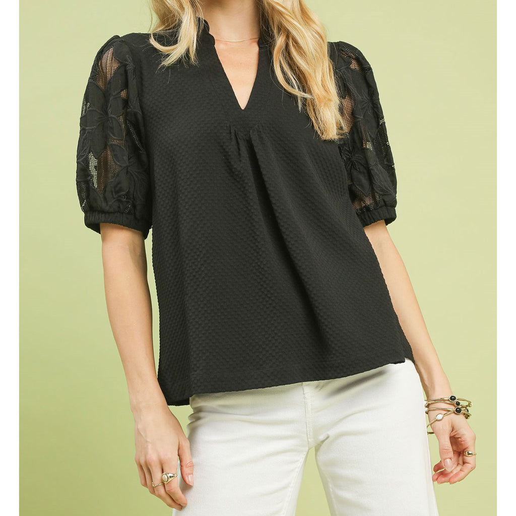 Woman wearing the Black Flower Lace Sleeve Blouse, front view showing the floral lace sleeves and cream bodice