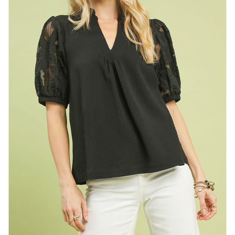 Woman wearing the Black Flower Lace Sleeve Blouse, front view showing the floral lace sleeves and cream bodice
