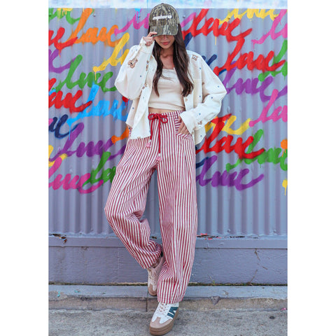 Model wearing red and white striped pants in a front view, showing the relaxed fit, vertical stripe pattern, and soft lightweight fabric.