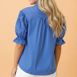 Back view of a model in the blue and white stripe ruffle puff sleeve button‑front blouse, showing the clean stripe layout and relaxed silhouette.