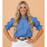 Model wearing the blue and white stripe ruffle puff sleeve button‑front blouse, front view showing the puff sleeves, ruffle trim, and classic stripe pattern.