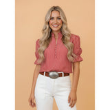 Model wearing the red and white striped puff sleeve blouse, front view showing the bold stripe pattern, puff sleeves, and feminine silhouette.