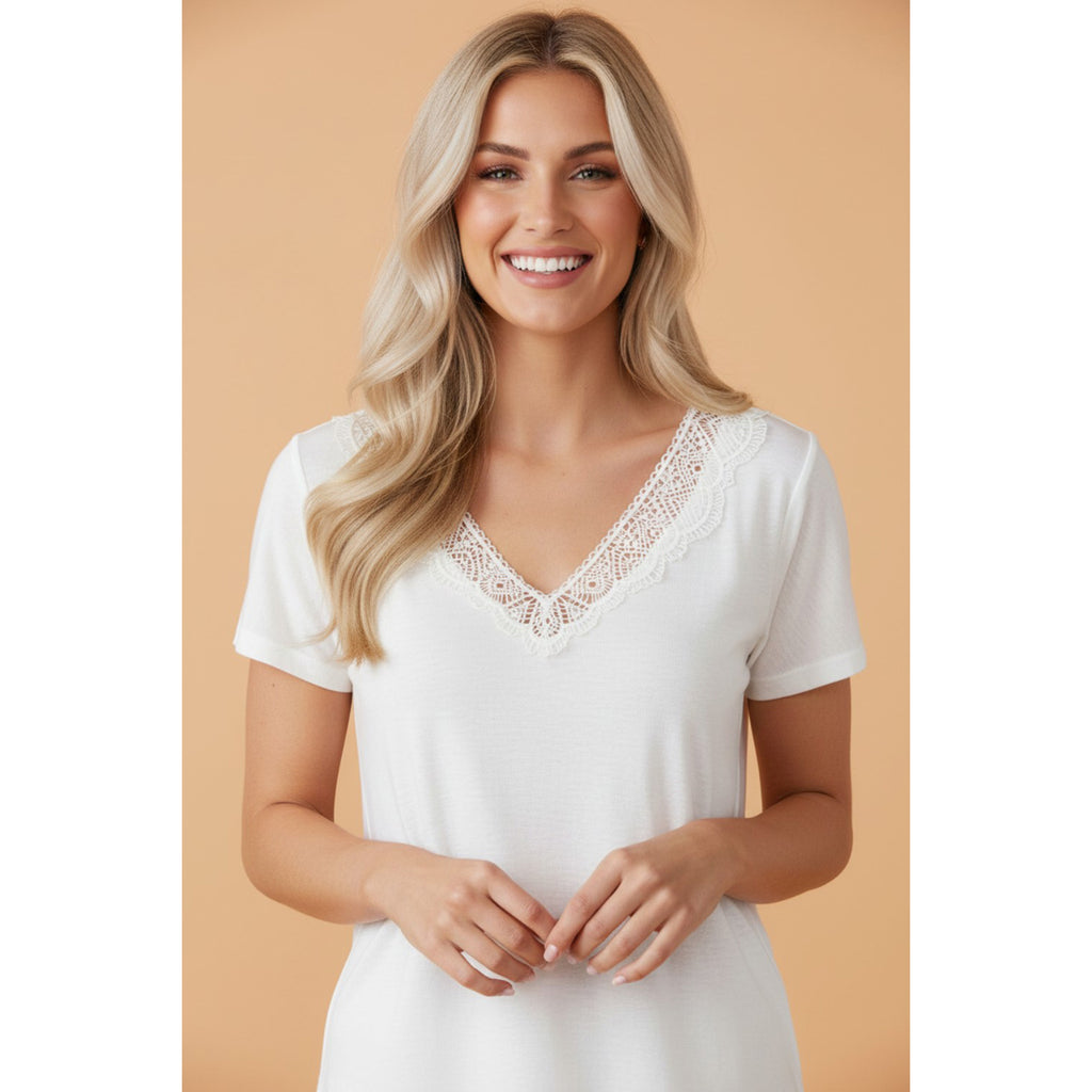 Front view of a model wearing the white lace V‑neck tee, showing the soft lace accents and flattering neckline in a relaxed, everyday fit.