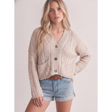 Model wearing a sand‑colored knotted front cardigan sweater, front view showing the soft knit fabric, relaxed fit, and charming knotted detail.