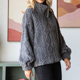 Woman wearing a gray cable knit sweater