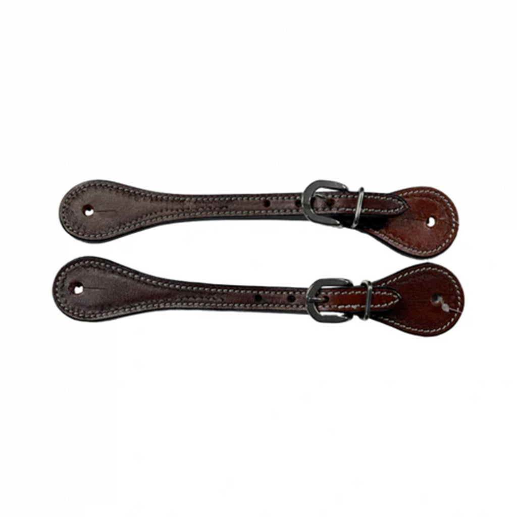 Set of brown tooled spur straps laying next to each other horizontally.