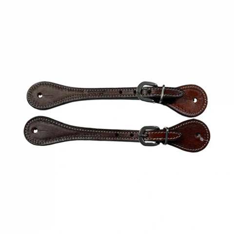 Set of brown tooled spur straps laying next to each other horizontally.