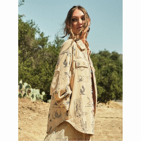 Woman wearing a beige shacket with western graphics printed all over