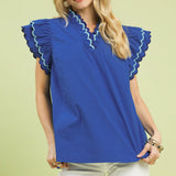 Close‑up of model wearing a solid ocean blue ruffle scalloped sleeve top focusing on the scalloped trim and ruffle sleeve detail, 