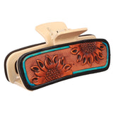 Close‑up of the sunflower tooled leather hair clip focusing on the detailed sunflower tooling and turquoise accents lighter clip