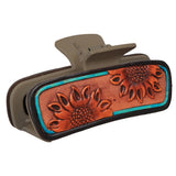 Close‑up of the sunflower tooled leather hair clip focusing on the detailed sunflower tooling and turquoise accents darker clip