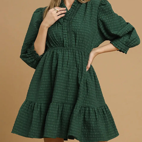 Dark green dress with waffle life material, long puffer sleeves, and crossover neck line. Thigh length dress.