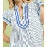 Close‑up of model wearing the blue striped scalloped trim flutter sleeve top focusing on the scalloped trim and striped fabric texture.