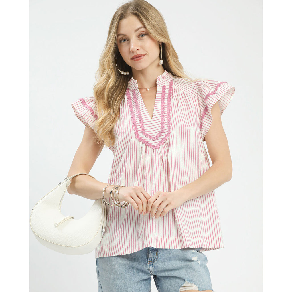 Woman wearing the Pink Striped Flutter Sleeve Top, front view showing the soft pink stripes and flutter sleeve detail 