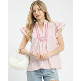 Woman wearing the Pink Striped Flutter Sleeve Top, front view showing the soft pink stripes and flutter sleeve detail 
