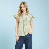 Model wearing a sage striped scalloped trim flutter sleeve top, front view showing the scalloped neckline and soft flutter sleeves.