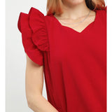 Close‑up of model wearing a red seersucker ruffle sleeve shift dress focusing on the seersucker texture and ruffle sleeve detail.