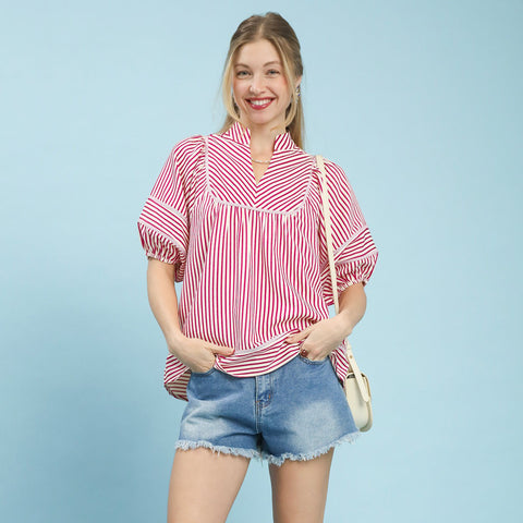 Model wearing a raspberry and white striped puff sleeve babydoll top, front view showing the puff sleeves, striped pattern, and flowy babydoll silhouette.