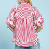 Back view of model wearing a raspberry and white striped puff sleeve babydoll top showing the smooth back and easy, flowy fit.