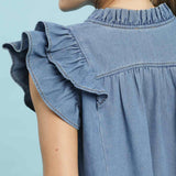 Close‑up of the denim tiered ruffle sleeve top on a model, focusing on the layered ruffle detailing and soft woven denim texture.