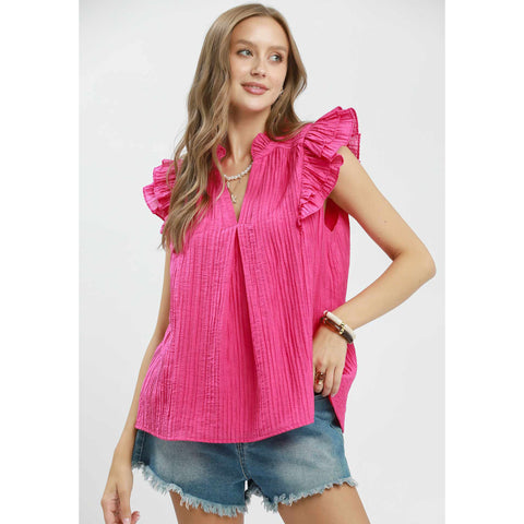 Front view of model in fuchsia textured V‑neck top with ruffle sleeve detail.